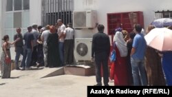 Turkmen wait in line to buy groceries at a food store. (file photo)