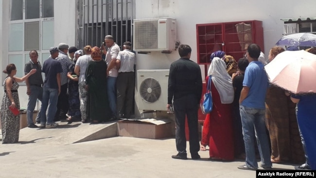 Turkmen wait in line to buy groceries at a food store. (file photo)