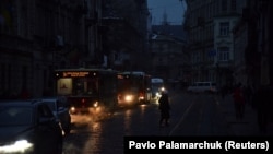 Vehicles drive in darkness in the center of Lviv, one of several Ukrainian cities that have experienced power outages this week as a result of Russian strikes on the country's infrastructure. 