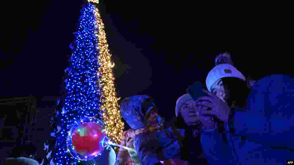 A járókelők szelfiznek Kijev karácsonyfájával a Szent Szófia téren