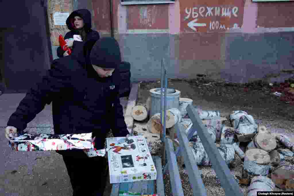 Volodymyr, 11, tears the packaging off his Christmas gift near the entry to an underground shelter. Kaszuwara will be spending several days traveling around Ukraine delivering Christmas presents collected from international donors.&nbsp;