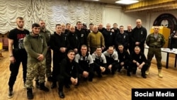 Wagner mercenary chief Yevgeny Prighozin (center, brown jacket) poses in January with a group of former Russian prisoners who were pardoned in exchange for their commitment to fighting for Wagner in Ukraine. 