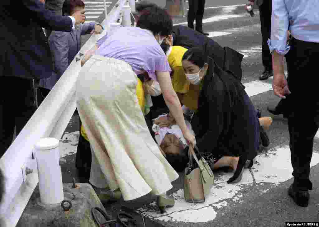Fostul premier japonez Shinzo Abe zace la pământ după ce a fost împușcat la un miting electoral la Nara, vestul Japoniei, 8 iulie 2022. Abe a murit în aceeași zi din cauza rănilor. (Kyodo via Reuters)