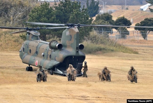 Десантники Сухопутных войск Японии на мотоциклах выезжают из вертолета CH-47 во время учений