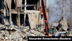 Workers clear the site following an attack by Ukrainian forces on a barracks where the Russian soldiers were stationed in Makiyivka, Donetsk region, on January 3.