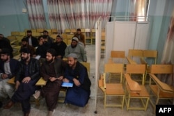 Studentë të universitetit ndjekin ligjëratat në klasën e ndarë me perde në pjesën për studentet vajza dhe gra në një universitet në provincën Kandahar më 21 dhjetor 2022. Udhëheqësit talibanë të Afganistanit e kanë ndaluar arsimin universitar për vajzat dhe gratë në mbarë vendin.
