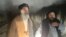 Two men walk away from the scene of the explosion in the Salang Tunnel, located about 130 kilometers north of Kabul, on December 18.