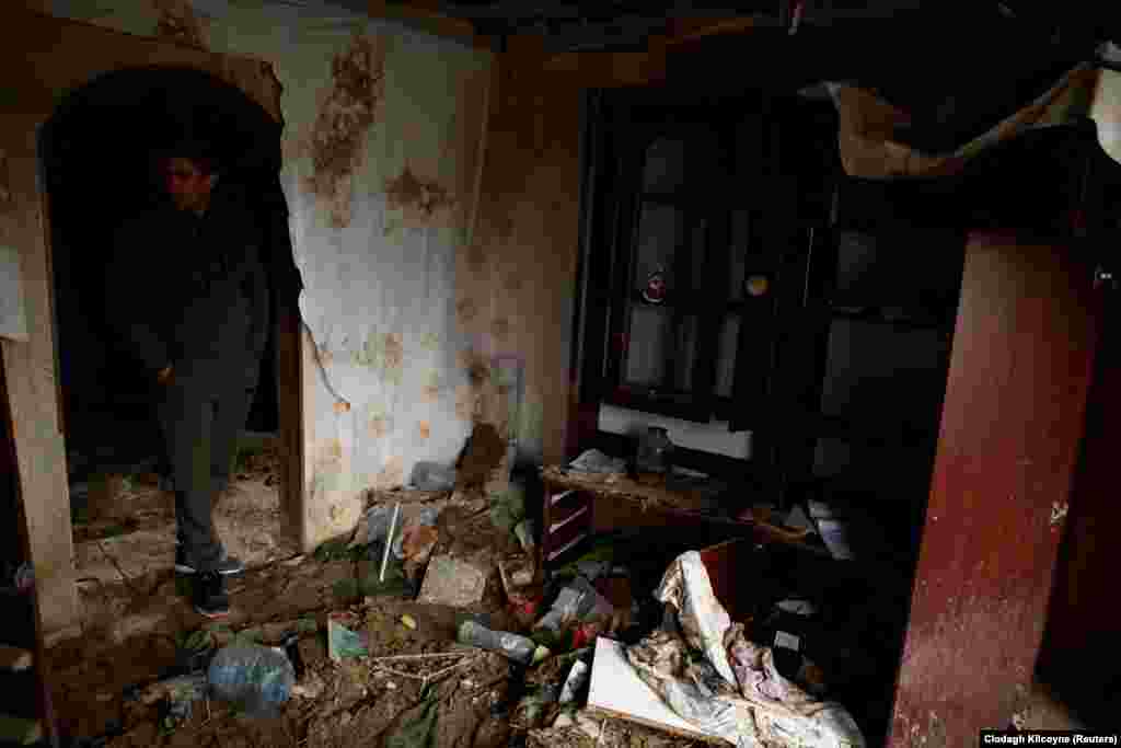 Mykola Melenets walks through Oleksandr&#39;s destroyed home. He has been trying to piece together what happened to his brother and their father, Serhiy, 62, who has been missing since late March.