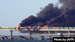 Black smoke billows from a fire on the Kerch bridge that links Crimea to Russia after a truck exploded near Kerch on October 8, 2022.