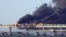 Black smoke billows from a fire on the Kerch bridge that links Crimea to Russia after a truck exploded near Kerch on October 8, 2022.