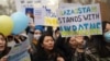 Демонстранты держат плакаты во время митинга в поддержку Украины в Алматы 6 марта 2022 года