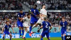 Players fight for a header during the World Cup group B soccer match between Iran and the United States in Doha on November 29.