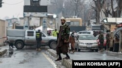 Припадник на талибанските безбедносни сили стои на блокиран пат по самоубиствената експлозија во близина на Министерството за надворешни работи во Кабул
