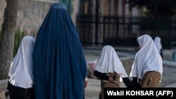 Žena vodi tri djevojčice u osnovnu školu u Kabulu, avgust 2022. Samo djevojčice do šestog razreda smiju pohađati školu u Avganistanu, dok su srednja i fakultet za žene zabranjeni pod talibanskom vlašću