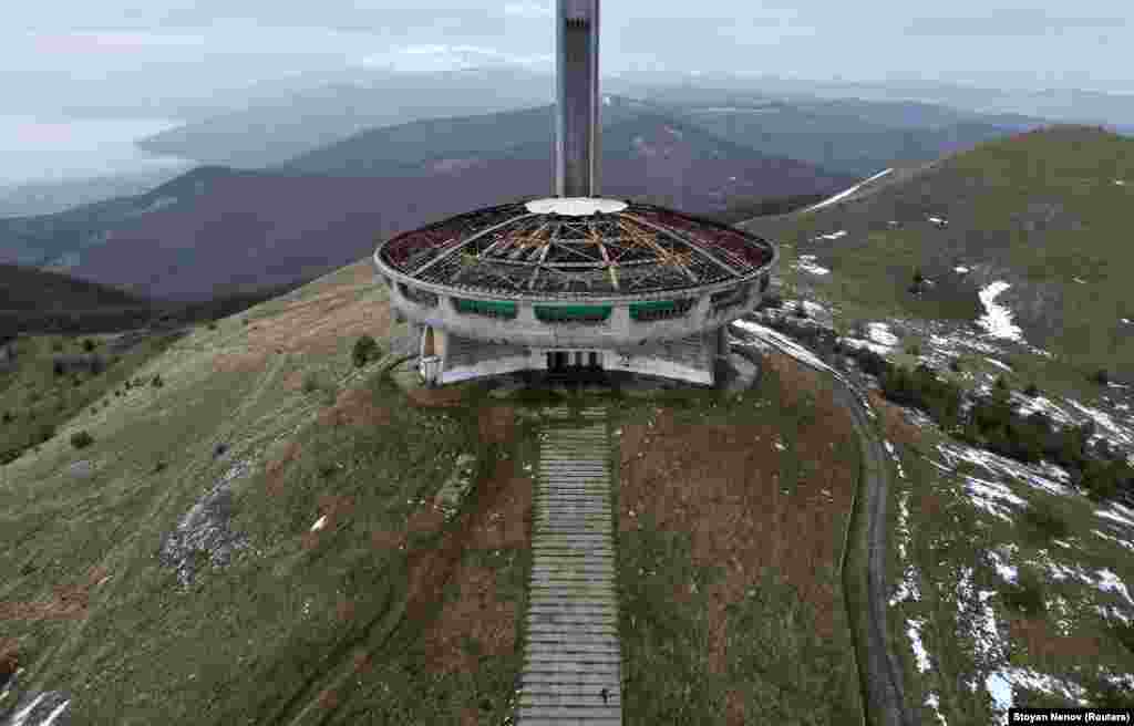 A person walks toward the Buzludzha monument at Buzludzha peak, atop Stara Planina mountain in Bulgaria on December 9, at the end of its first restoration stage and before its official opening in 2023.