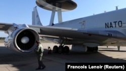 A NATO officer inspects an AWACS aircraft as it prepares to take off for a training mission. (file photo)