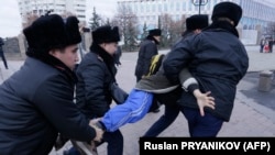 Қазақстандықтар кезектен тыс президент сайлауға дауыс берген күні наразылық білдіріп шықққан адамды күштеп әкетіп бара жатыр. Алматы, 20 қараша, 2022 жыл.