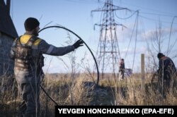 Енергетики намагаються полагодити пошкоджену російським обстрілом лінію електропередачі поблизу Краматорська на Донеччині, грудень 2022 року