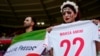 Iran fans hold a "Women, life, freedom" Iranian flag and a replica shirt in memory of Mahsa Amini inside the stadium in Qatar before the match with Wales on November 25.