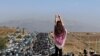 IRAN -- This UGC image posted on Twitter reportedly on October 26, 2022 shows an unveiled woman standing on top of a vehicle as thousands make their way towards Aichi cemetery in Saqez, Mahsa Amini's home town in the western Iranian province of Kurdistan