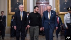 Ukrainian President Volodymyr Zelenskiy (center) walks with Senate Minority Leader Mitch McConnell (left) and Senate Majority Leader Chuck Schumer at the U.S. Capitol on December 12. 