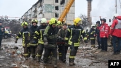 Rescue workers remove the body of a civilian following a missile strike on the central Ukrainian city of Poltava on February 1. 