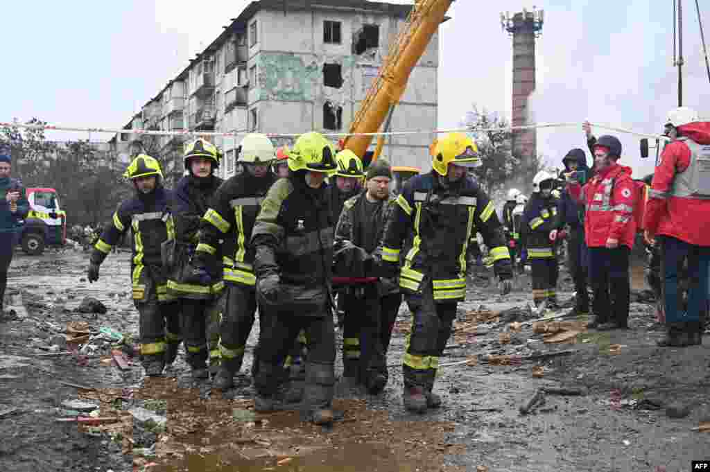 Rescue workers remove the body of a civilian following a Russian missile strike on the central Ukrainian city of Poltava on February 1.