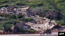 An Israeli military vehicle drives along the road between destroyed houses in southern Lebanon on April 25.