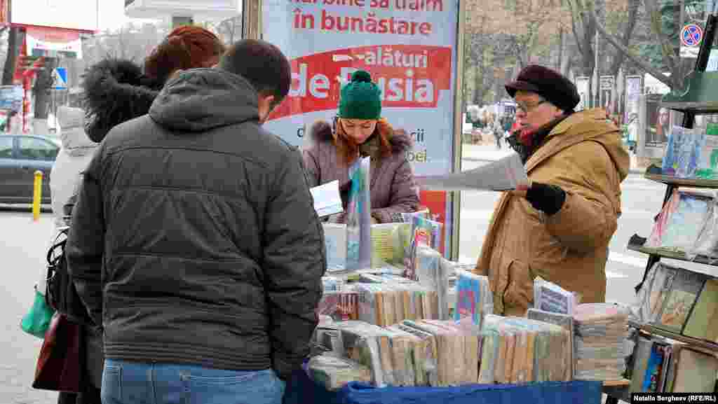 O doamnă vinde cărţi în centrul capitalei, lângă publicitatea electorală a Partidului Socialist.&nbsp; 