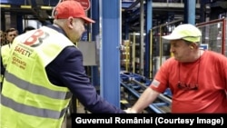 Vizita premierului Marcel Ciolacu (stânga) la fabrica Coca Cola din Ploiești, pe 4 octombrie 2023. Compania a primit ajutoare de stat de 3,07 milioane de euro, a promis cinci noi locuri de muncă și a creat șase.