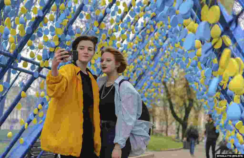 Ukrainians take a selfie at an art installation called&nbsp; A Corridor Of Life, a tribute to Ukrainians killed in the Russian invasion, in Lviv on April 15.&nbsp;