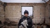 Ukraine War n-- Danyk Rak, 12, holds a cat standing on the debris of his house destroyed by Russian forces' shelling in the outskirts of Chernihiv, Ukraine, Wednesday, April 13, 2022.