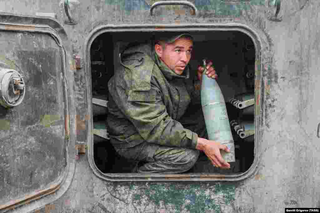 Пророссийский боевик держит снаряд в самоходной гаубице Гвоздика 2С1 в Первомайске, Луганской области