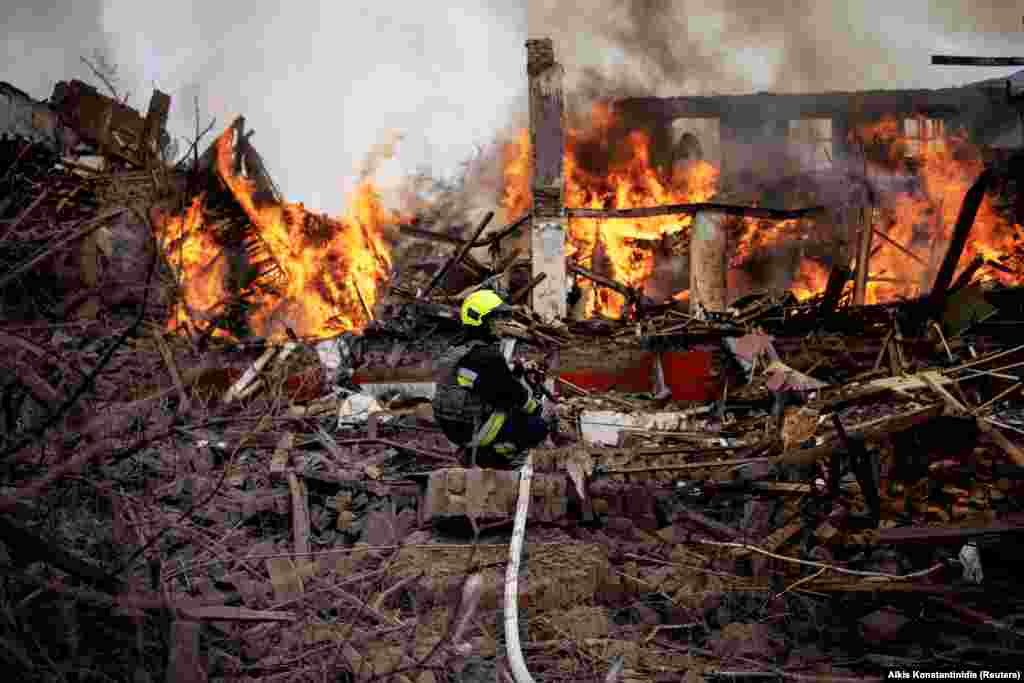 Пожарный на месте загоревшихся в результате ракетного обстрела зданий возле харьковского аэропорта, 12 апреля