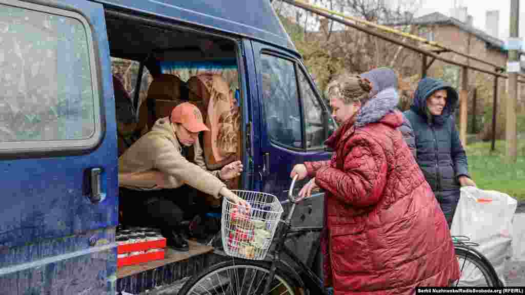 Волонтер Тетяна роздає продукти місцевим жителям на одній з вулиць Мар&lsquo;їнки. 14 квітня 2022 року. За словами волонтерів у місті залишилось ще багато місцевих жителів, які з різних причин не евакуйовуються із зони бойових дій&nbsp;