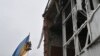 Radnici su 10. aprila 2022. godine, tokom ruske invazije na Ukrajinu, postavili ukrajinsku zastavu na jarbol uništene zgrade u centru Makariva, Kijevska oblast. 