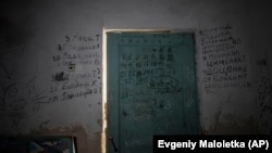 Написи на стінах та дверях в підвалі школи в Ягідному, поблизу Чернігова, зроблені місцевими жителями під час окупації. Зокрема, написані імена людей, які загинули під час російської окупації їхнього села. Ягідне, 12 квітня 2022 року