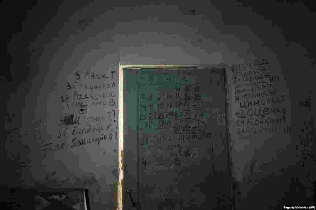 Az orosz megszállás alatt meghalt helyiek nevei borítják a falakat és az ajtót egy iskola pincéjében Jahidnében, Csernyihiv mellett, ahol több mint háromszáz ember húzta meg magát heteken át