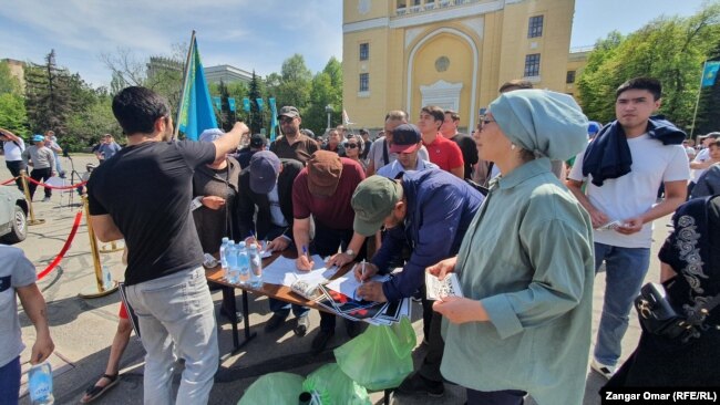 Митингующие подписывают резолюцию митинга, где говорится о ликвидации утильсбора в Казахстане. Алматы, 17 апреля 2022 года.