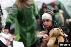 Украинский ребенок-беженец в очереди, среди тех, кто пытается пересечь украинско-польскую границу после бегства от российского вторжения в Украину, возле контрольно-пропускного пункта в Шегини, Украина, 31 марта 2022 года