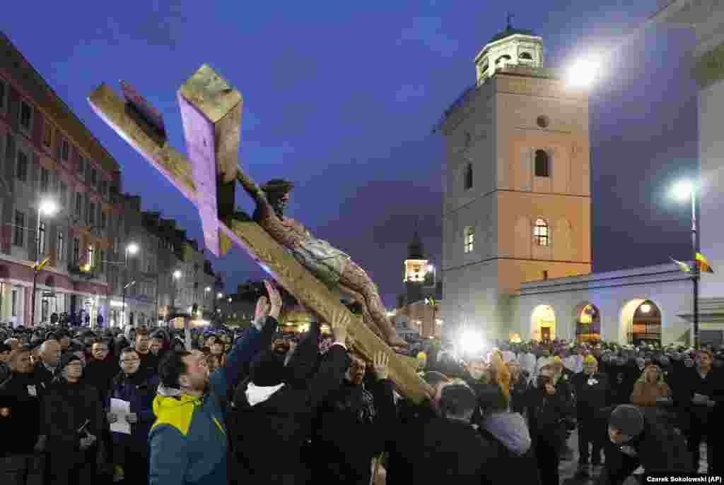 Worshipers hold a cross during the Way of the Cross procession in Warsaw. The Good Friday procession is a part of celebrations that end with Easter Sunday, the most important holiday for Catholics.