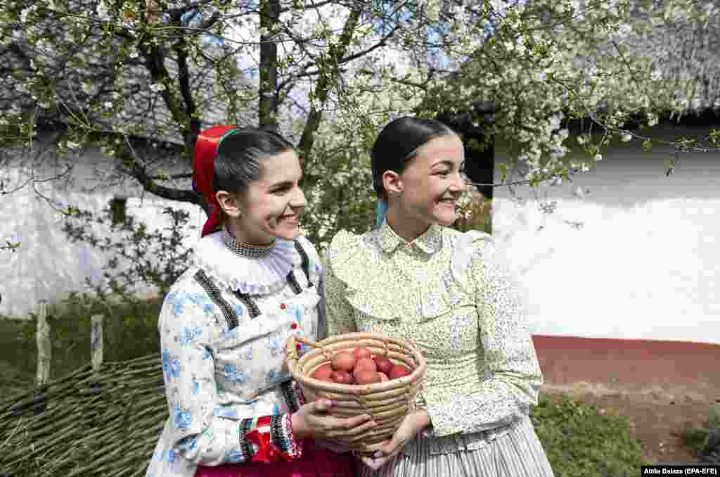 Dressed in folk costumes, female members of the Nyirseg Dance Ensemble hold a basket filled with colored eggs in Nyiregyhaza, Hungary, on April 18.