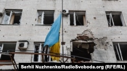 Прапор на адміністративній будівлі Мар'їнки, пошкодженій обстрілами російських військових