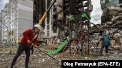Местные жители и спасатели убирают развалины разрушенного после российских обстрелов жилого дома в Бородянке, Украина 9 апреля 2022 года