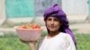 An Afghan laborer sorts strawberries at a farm in Kandahar.