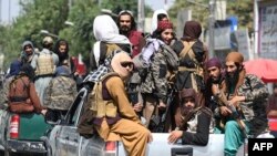 Taliban fighters patrol on vehicles along a street in Kabul on September 2, 2021. 