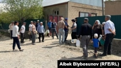 Жанармай құятын ыдысын ұстап, саудагерлерді күтіп тұрған адамдар. Баткен, Қырғызстан, 13 сәуір 2022 жыл.