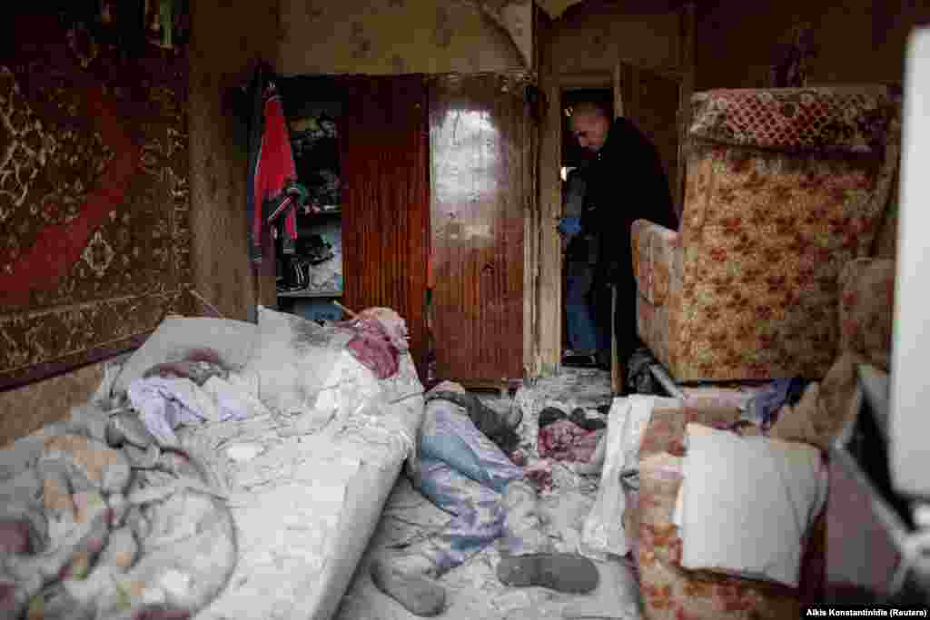 A Ukrainian emergency worker stands over the body of a 41-year-old resident who was killed during shelling that tore through his apartment in Kharkiv on April 13.&nbsp;