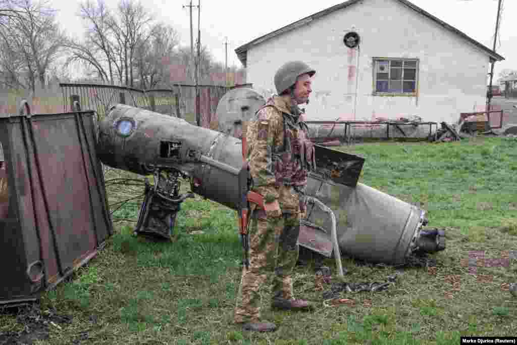 A Ukrainian soldier next to the remains of a missile near Barvinkove on April 11.&nbsp;