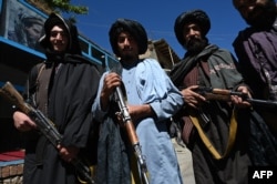 Taliban fighters pose for a picture in front of a bakery in the Khenj district of Panjshir Province in September.